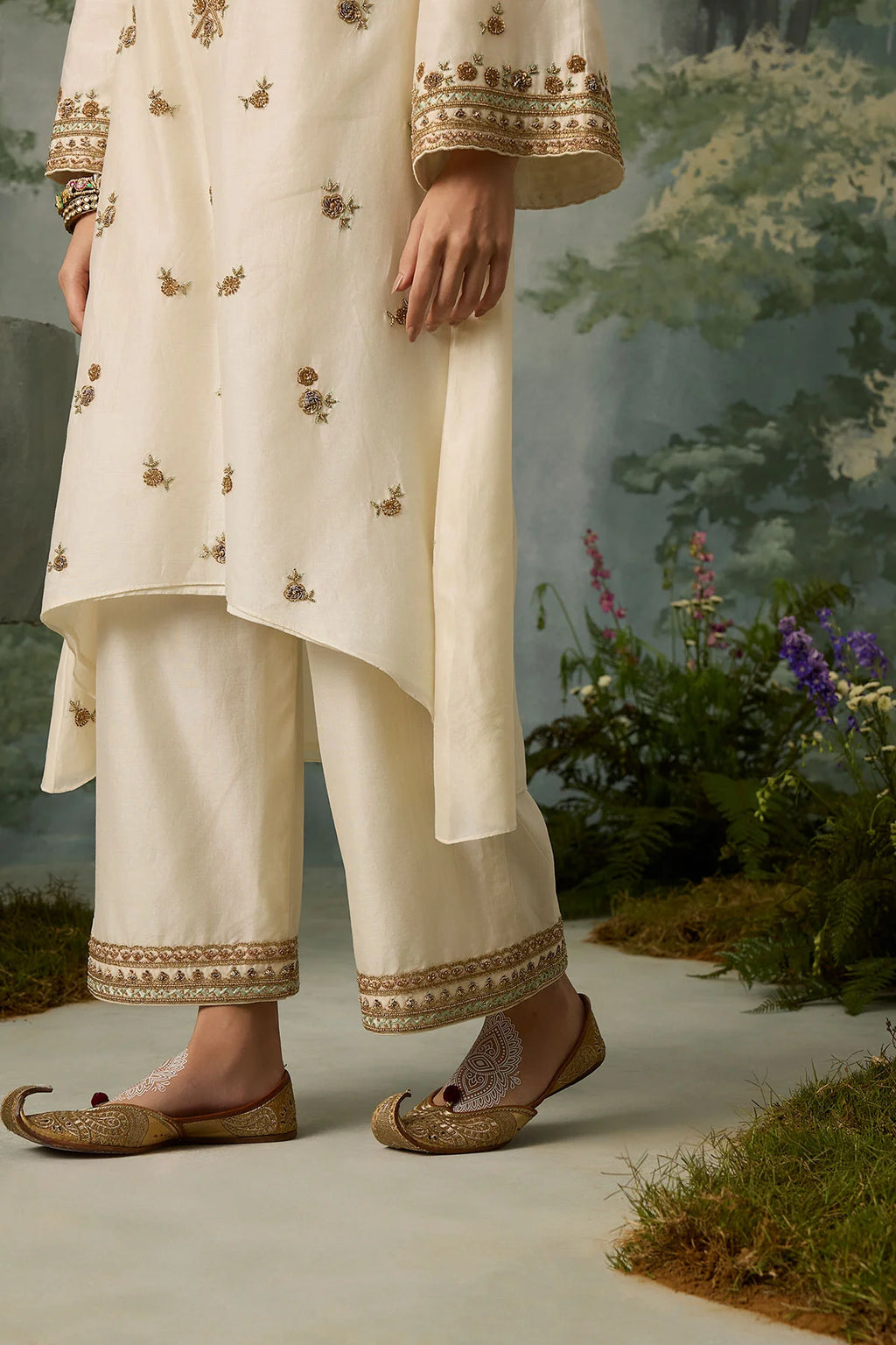 Person wearing a cream embroidered outfit with a natural outdoor background