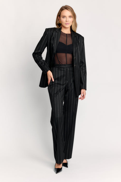 Woman wearing a black pinstripe suit on a white background
