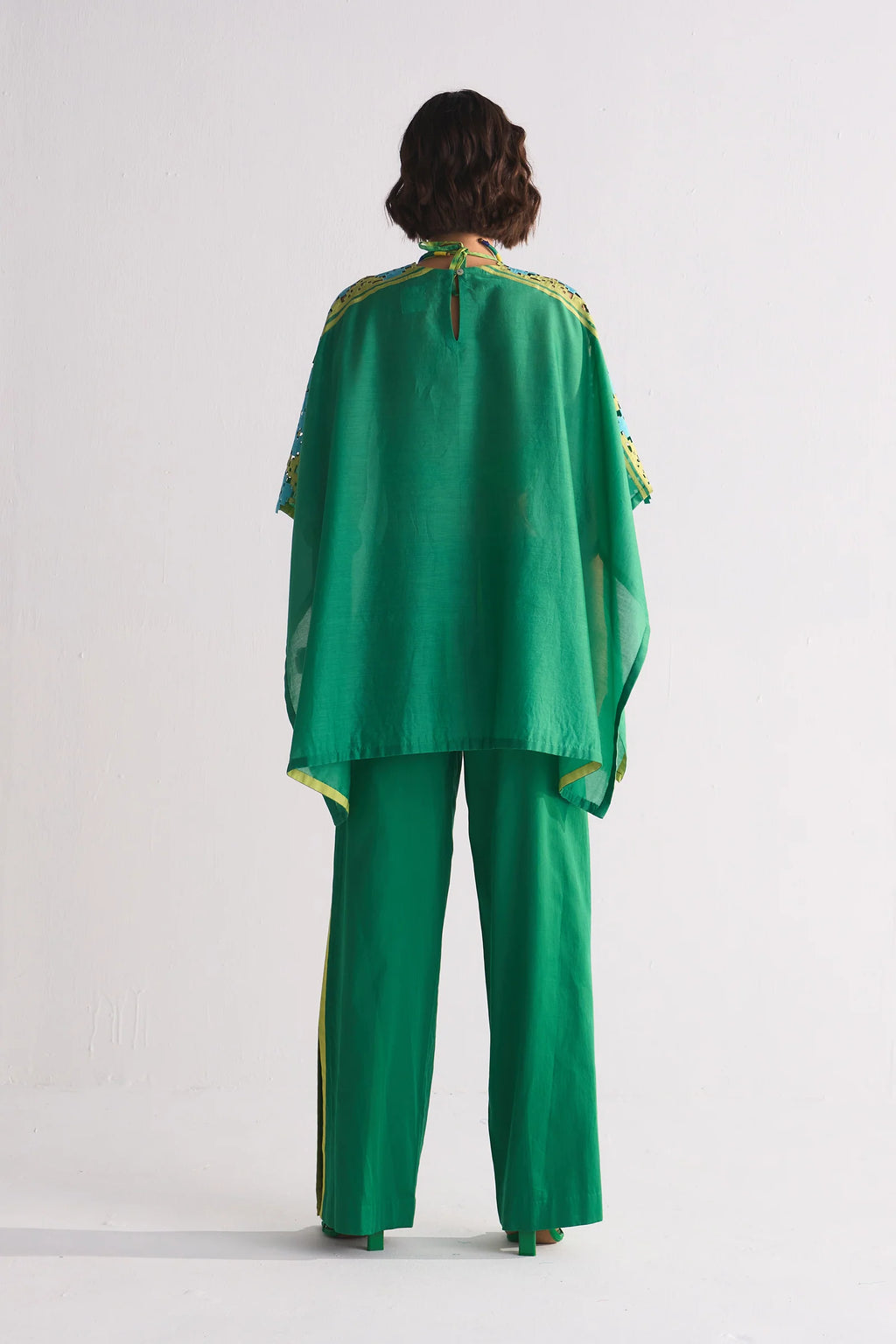 A vibrant green Chanderi shirt featuring blue and lime green geometric hand-cut appliqué and cutwork on the shoulders, paired with matching wide-leg trousers.