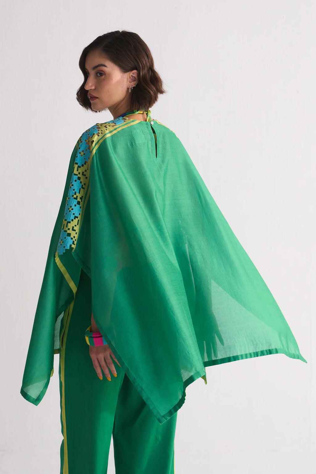 A vibrant green Chanderi shirt featuring blue and lime green geometric hand-cut appliqué and cutwork on the shoulders, paired with matching wide-leg trousers.