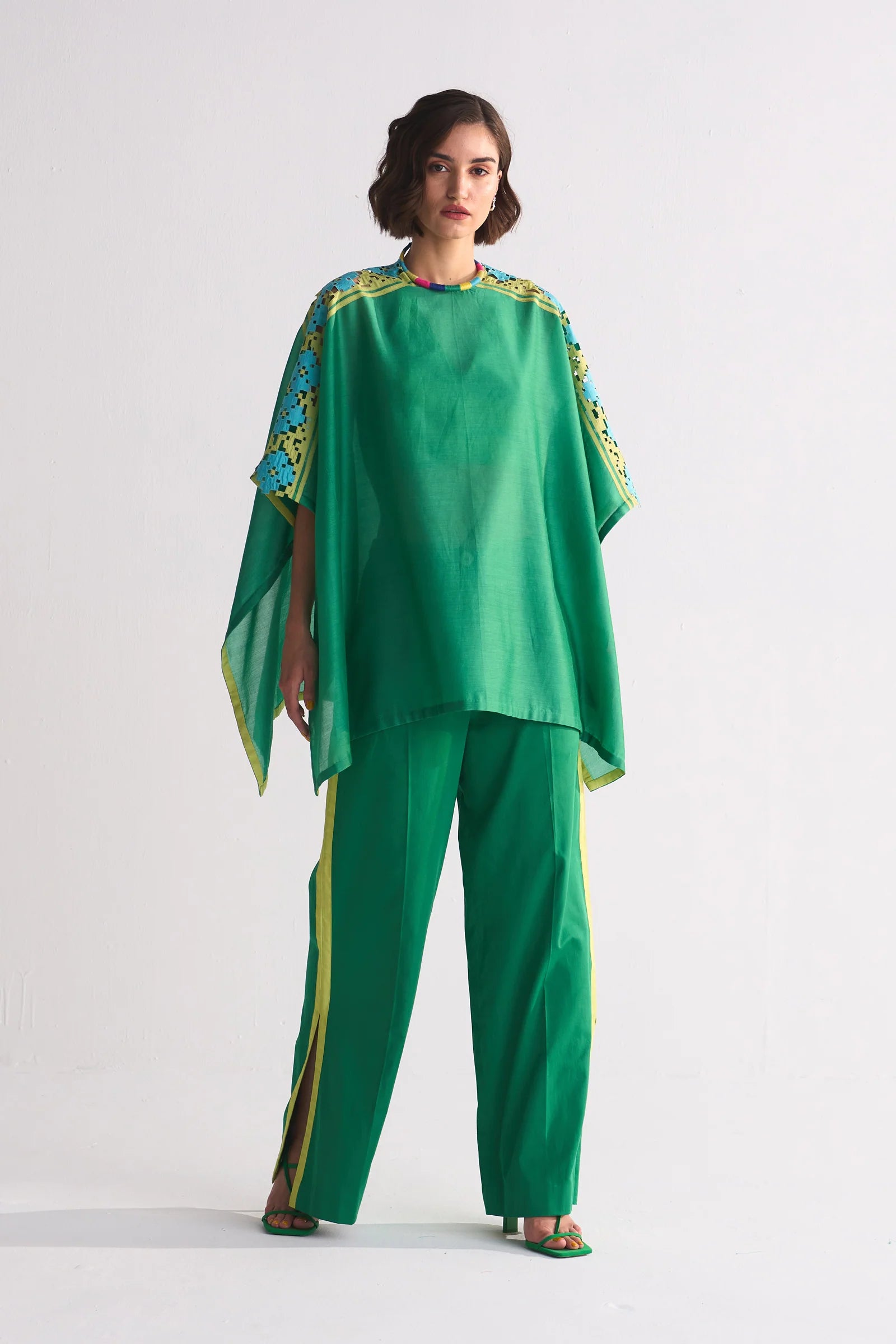 A vibrant green Chanderi shirt featuring blue and lime green geometric hand-cut appliqué and cutwork on the shoulders, paired with matching wide-leg trousers.