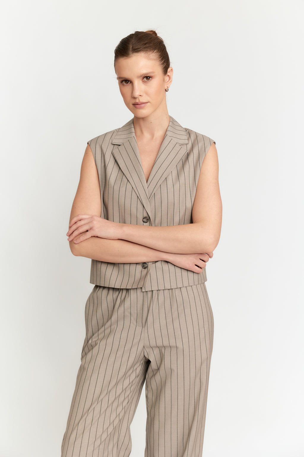 Woman wearing a beige pinstripe suit on a white background