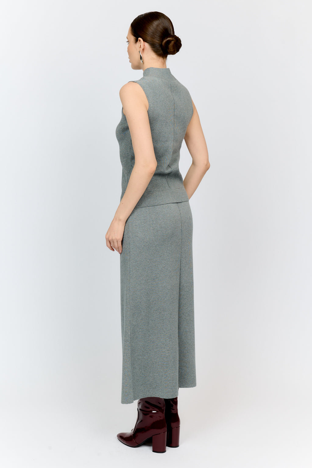 Woman wearing a gray sleeveless dress on a white background
