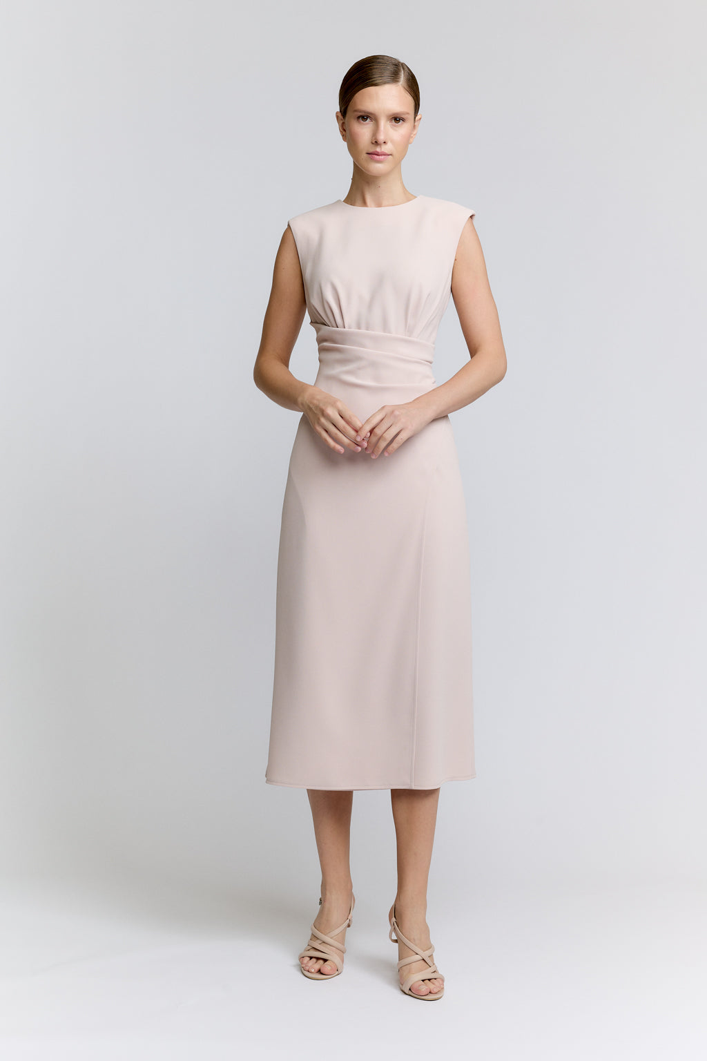 Woman wearing a light pink dress on a white background