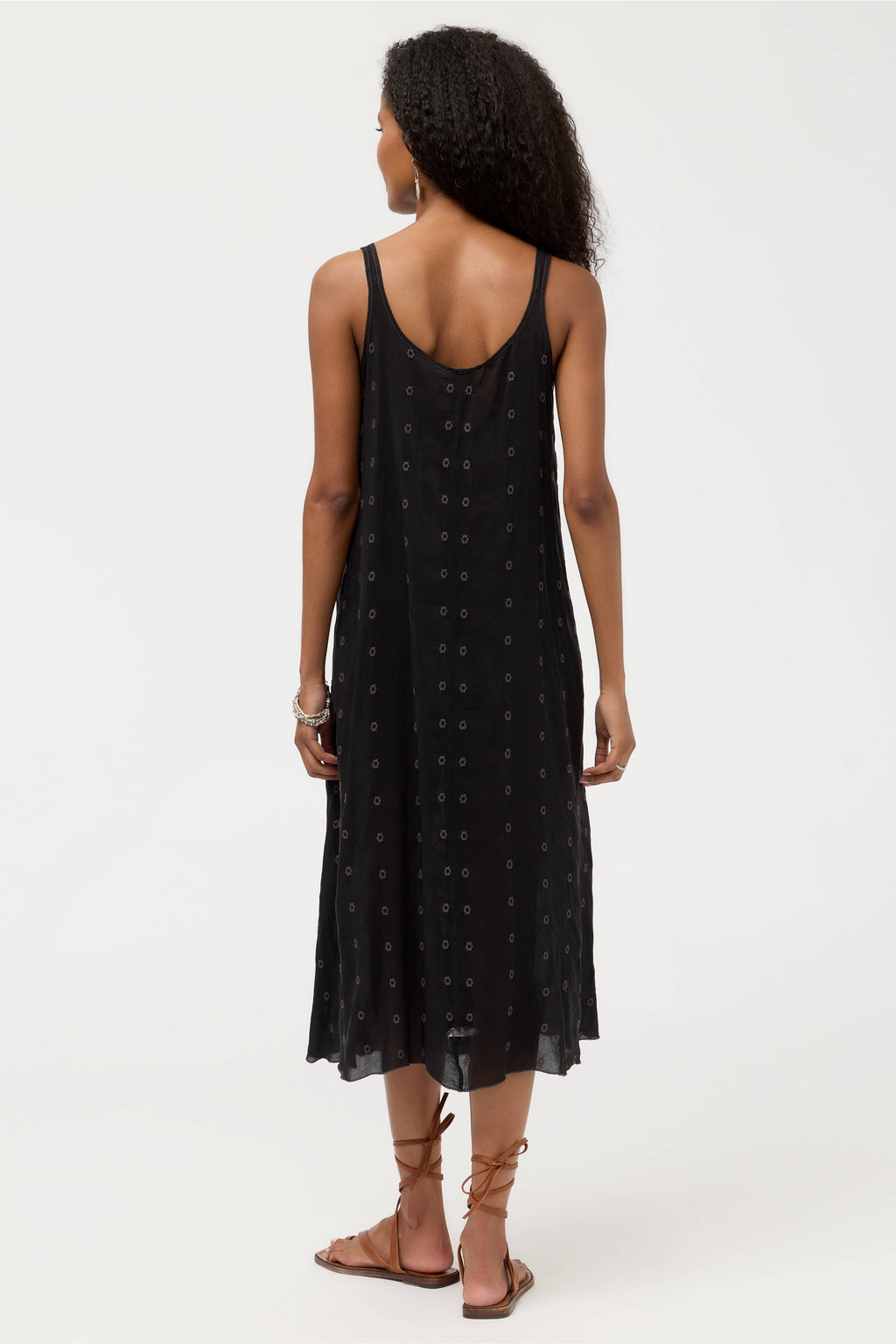 Woman wearing a black dress with a white polka dot pattern on a white background