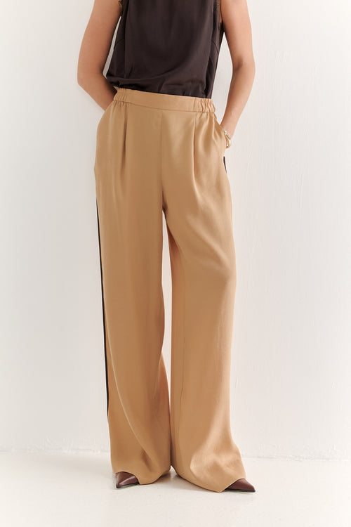 Beige wide-leg pants worn by a person on a white background