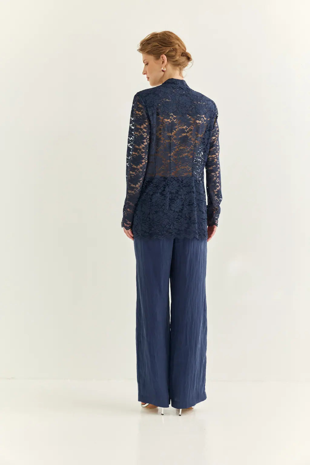 Ayra Store based in New York united states of America Woman wearing AYRA Vinyl Corded Lace Jacket with notched lapel and scalloped hem paired with fluid navy blue trousers