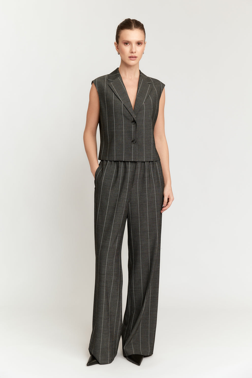 Woman wearing a gray pinstripe suit on a white background