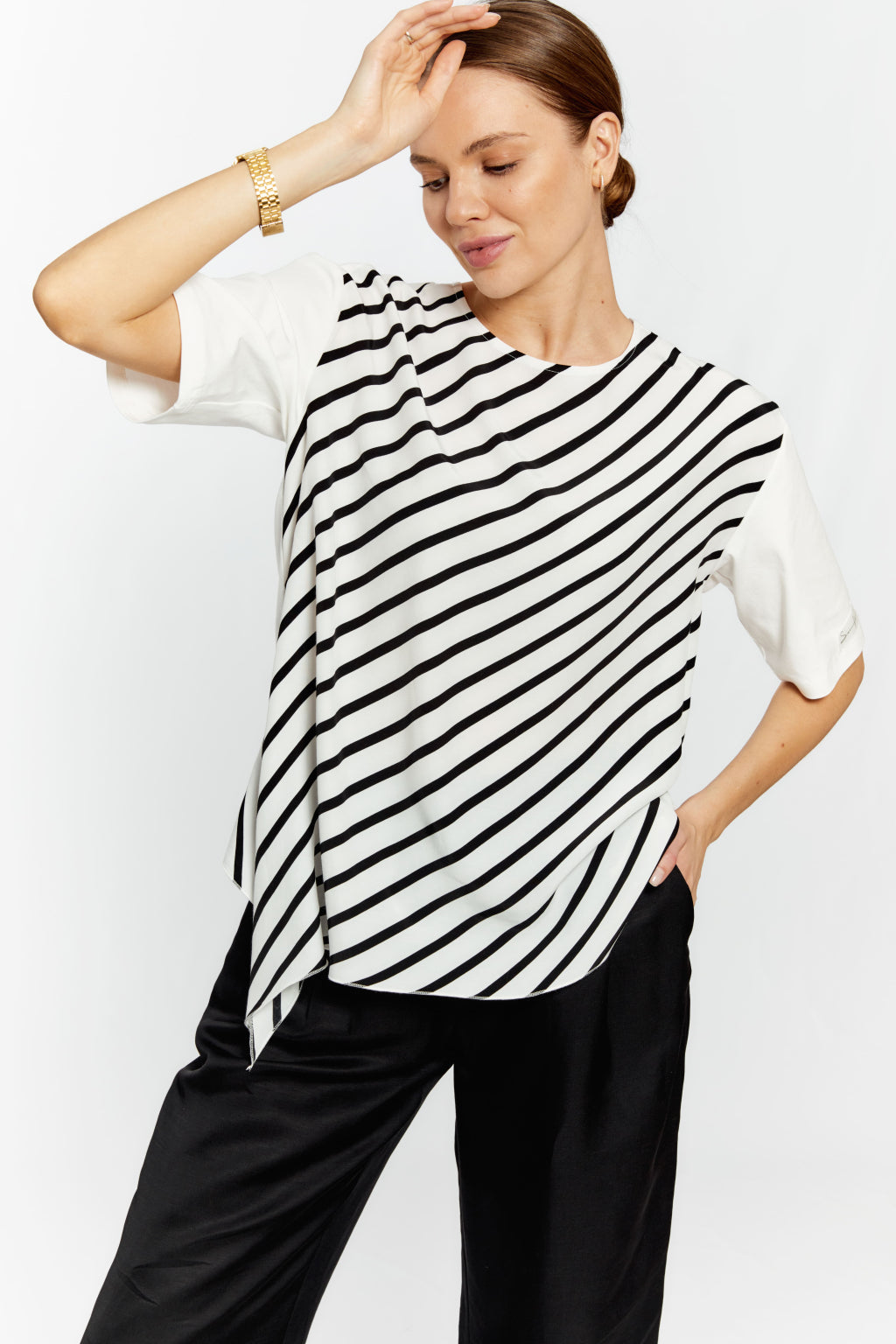 Woman wearing a black and white striped top with a plain background