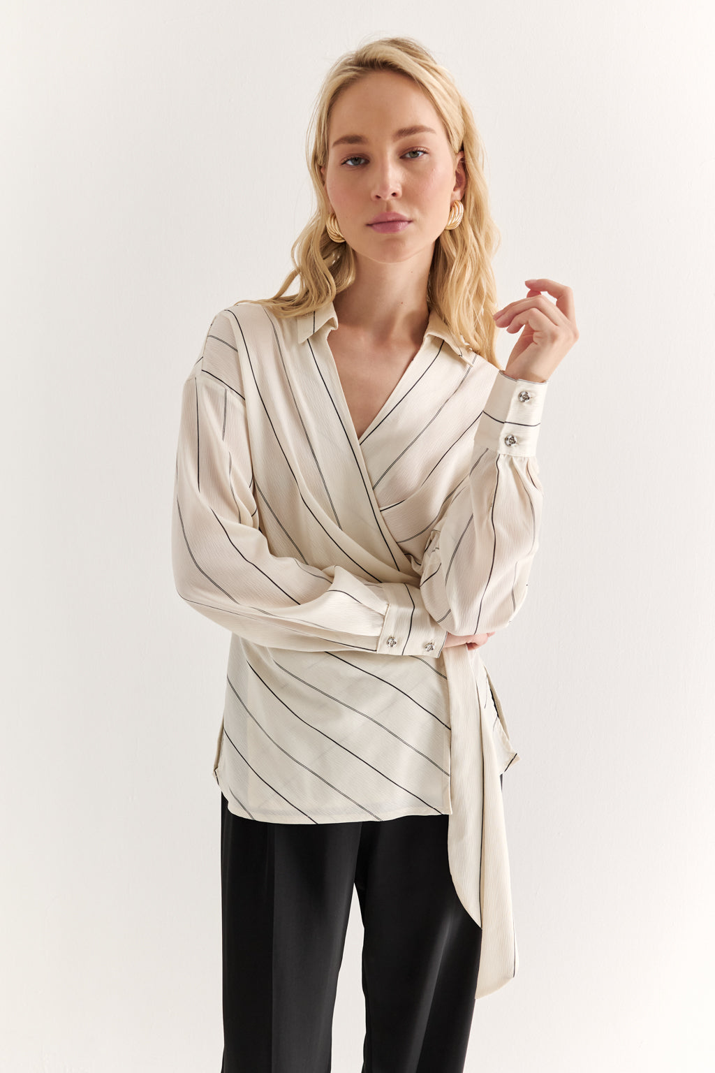 Woman wearing a beige striped blouse with a white background