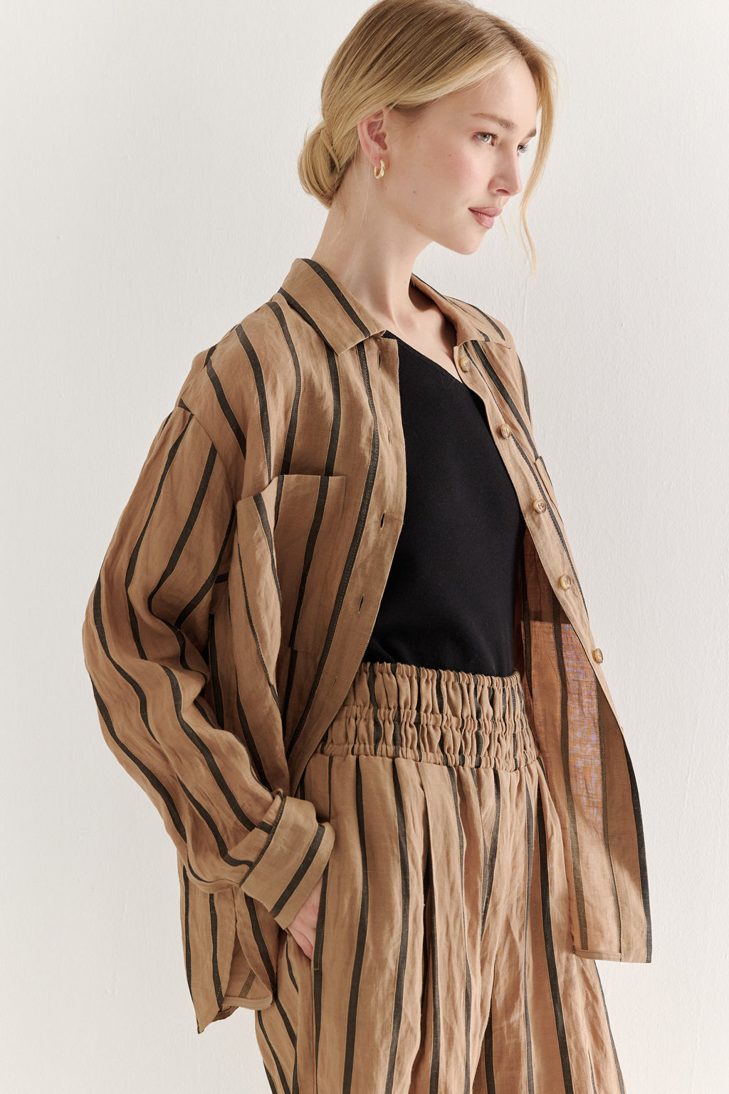 Woman wearing a brown striped outfit on a white background