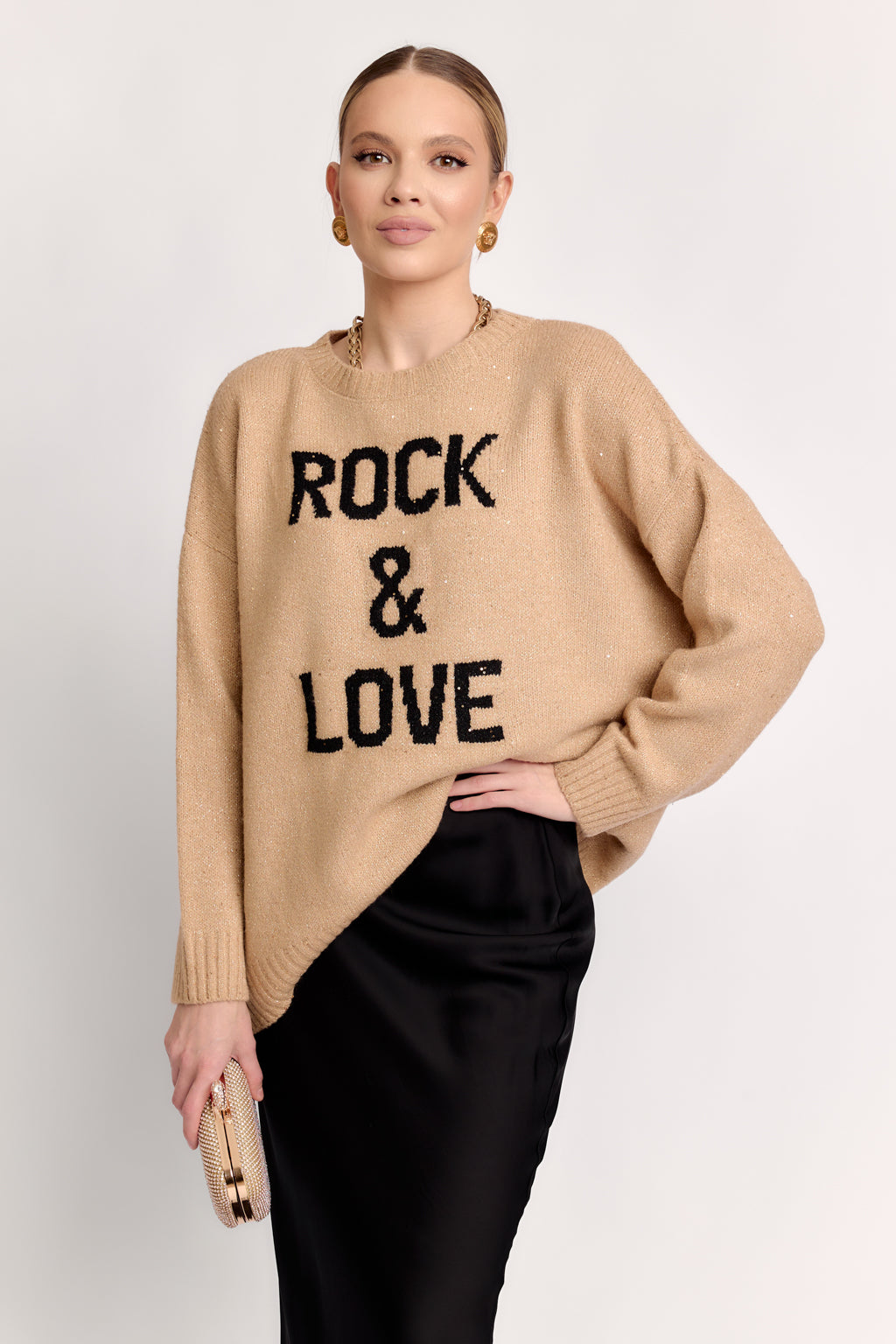 Woman wearing a beige sweater with 'ROCK & LOVE' text on a white background