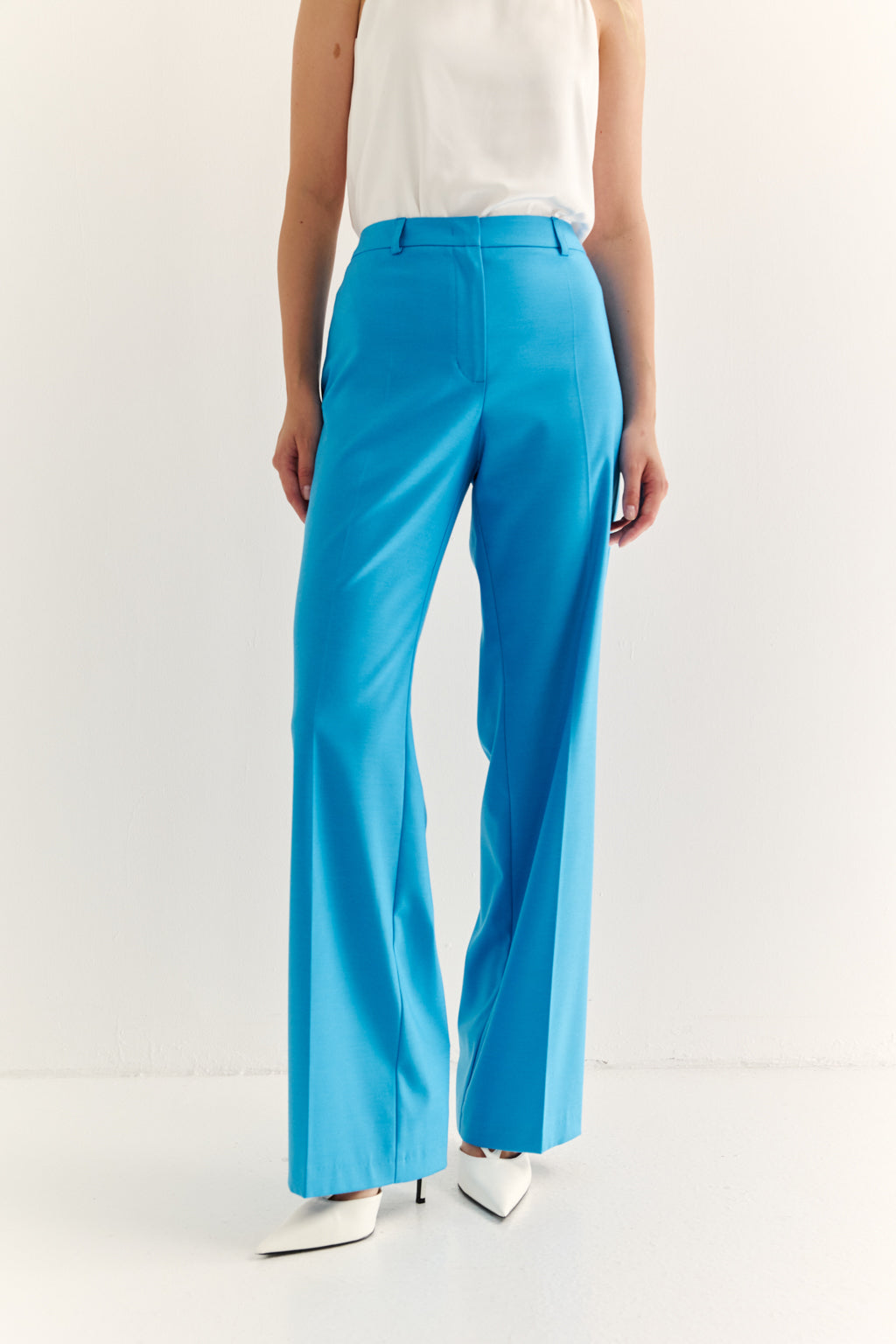 Person wearing bright blue pants on a white background