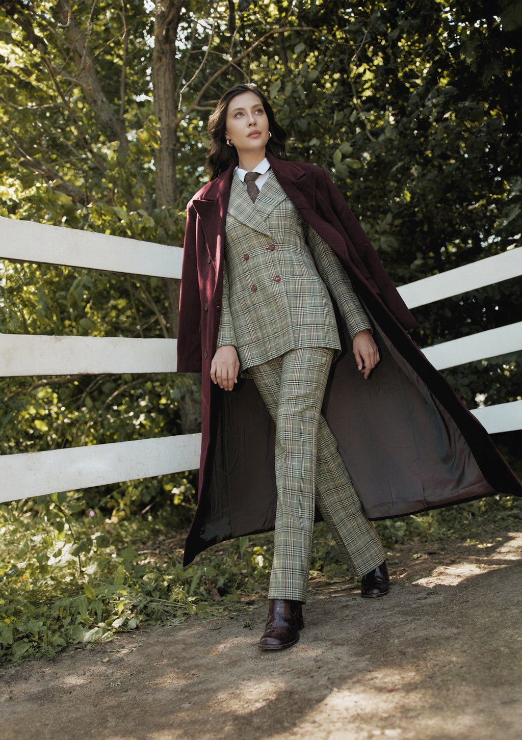 Woman in a vintage-style outfit standing outdoors with trees in the background