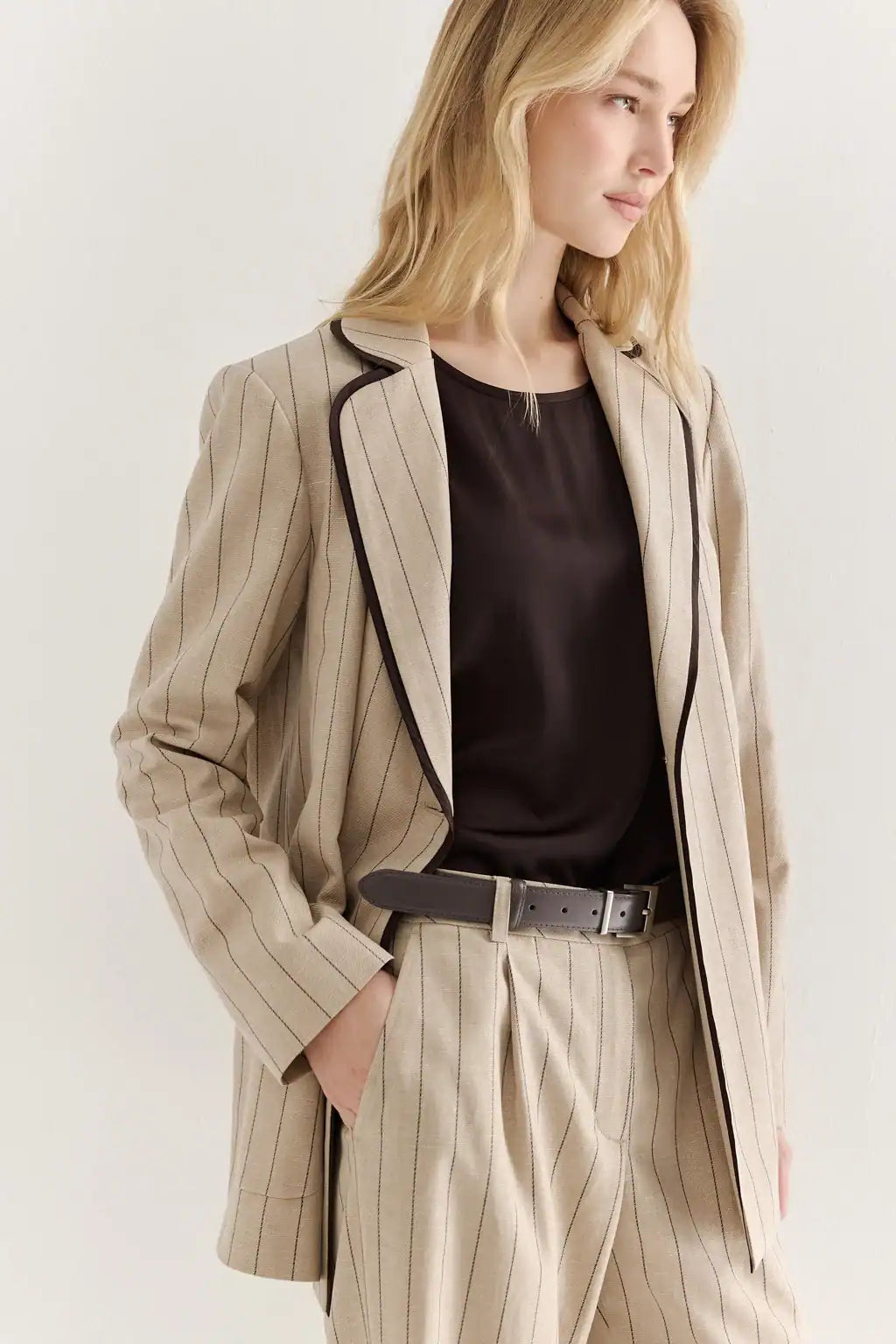 Beautiful Woman wearing AYRA STORE Sand Piped Safari Luxury Blazer in pinstriped lyocell-linen melange with dark contrasting piped trim