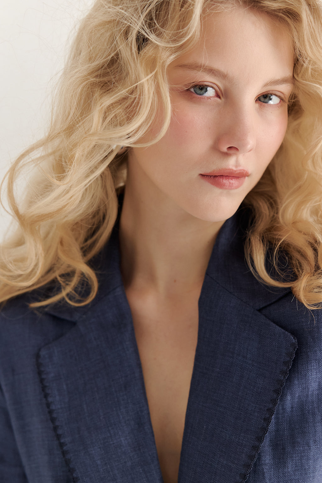 Woman wearing a blue blazer with a plain background