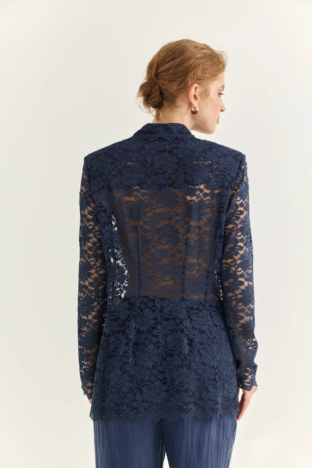 Ayra Store based in New York united states of America Woman wearing AYRA Vinyl Corded Lace Jacket with notched lapel and scalloped hem paired with fluid navy blue trousers