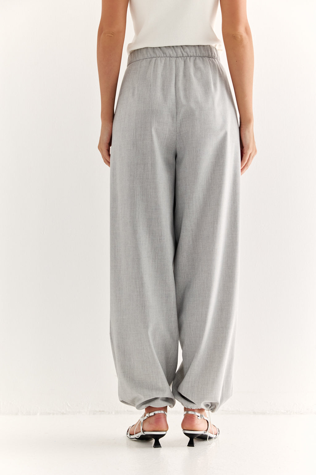 Light gray wide-leg pants worn by a person on a white background