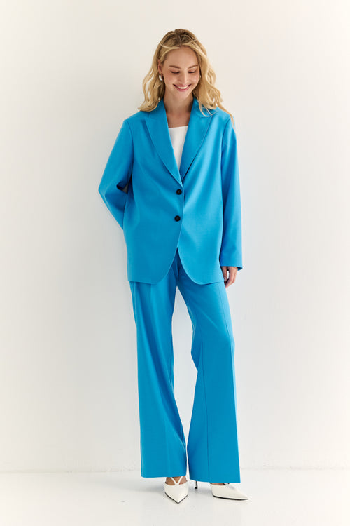 Woman wearing a bright blue suit on a white background