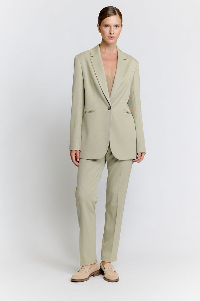 Woman wearing a beige suit on a white background