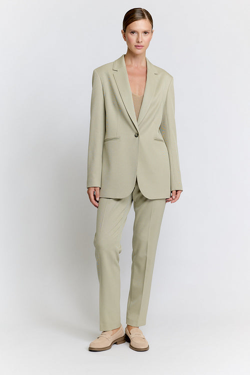 Woman wearing a beige suit on a white background