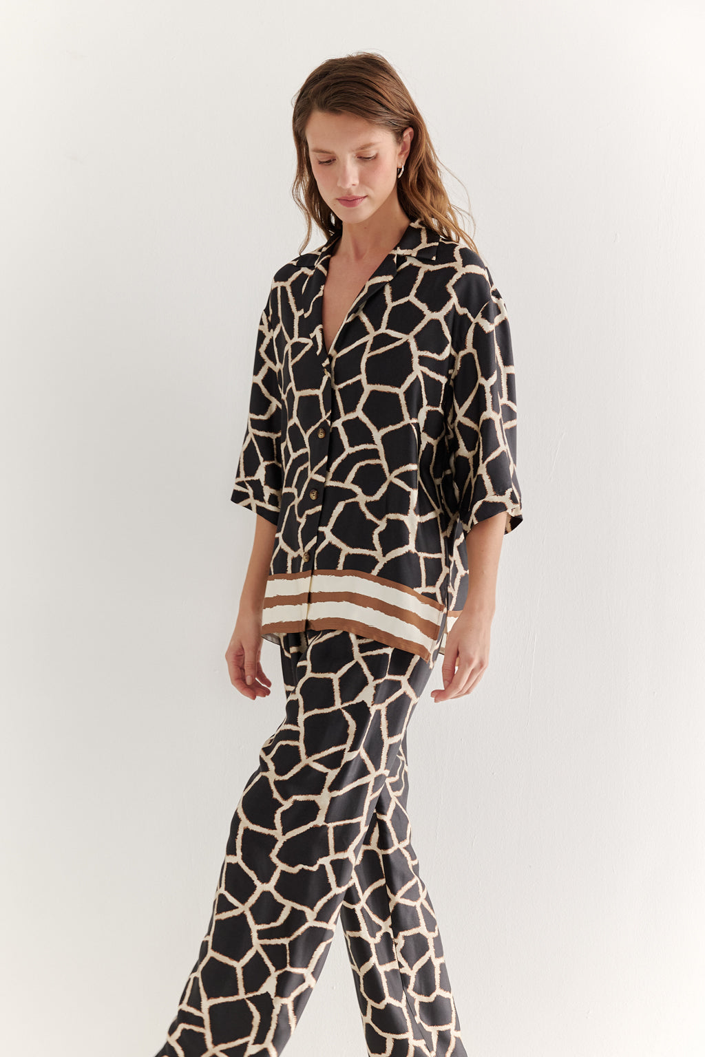 Woman wearing a giraffe print outfit on a white background