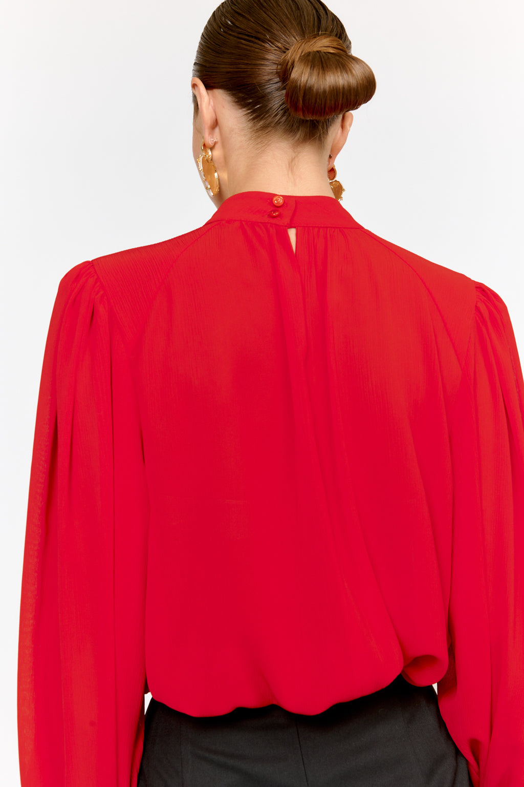 Red blouse worn by a person on a white background