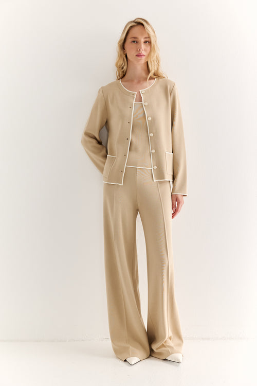 Woman wearing a beige pajama set on a white background