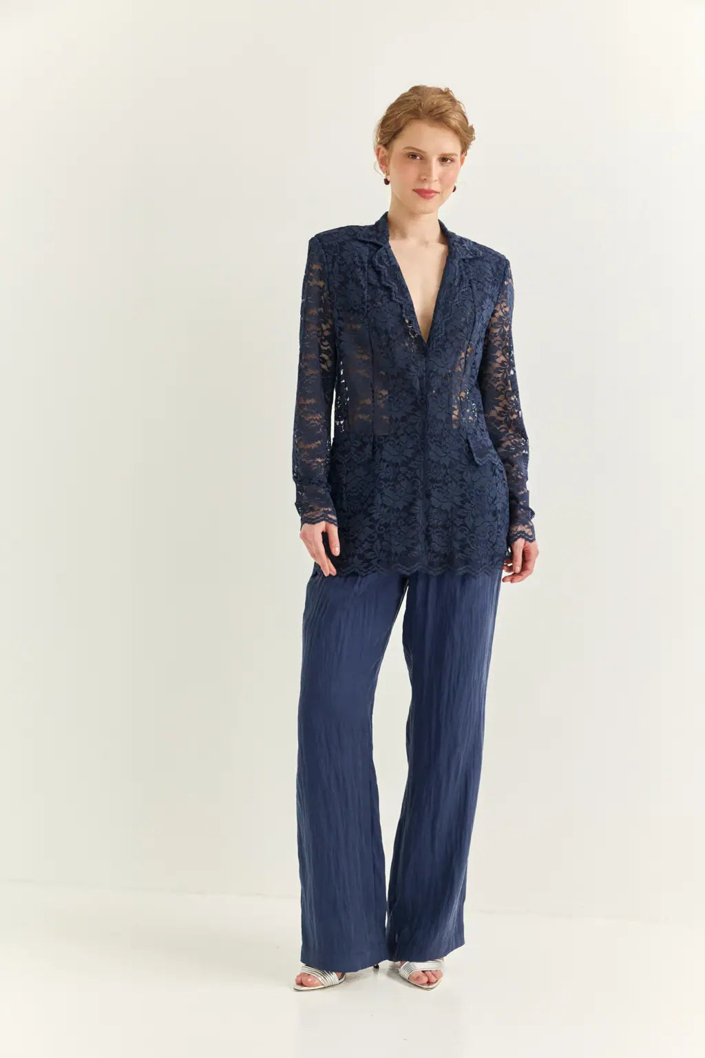 Ayra Store based in New York united states of America Woman wearing AYRA Vinyl Corded Lace Jacket with notched lapel and scalloped hem paired with fluid navy blue trousers