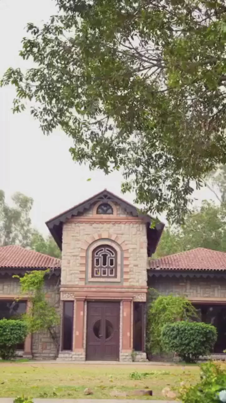 Woman in a peach embroidered outfit holding a teacup outdoors.