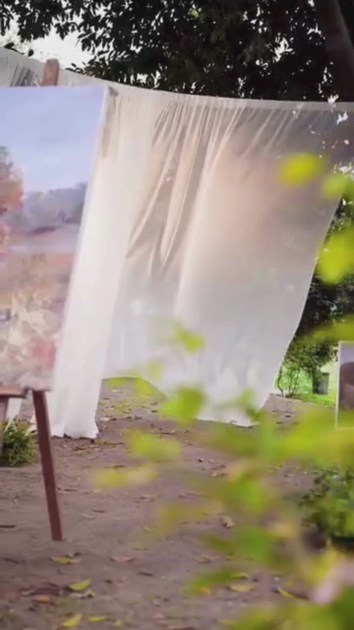 Woman in a traditional outfit standing outdoors with a white picket fence and garden in the background