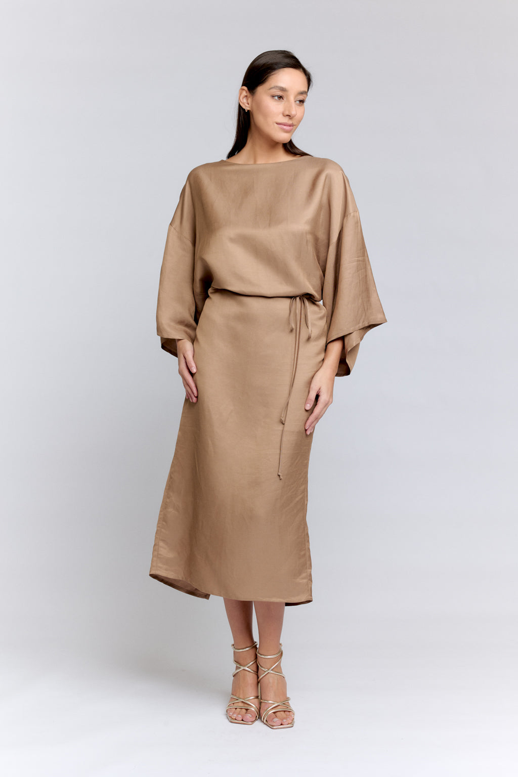 Woman wearing a beige outfit on a white background