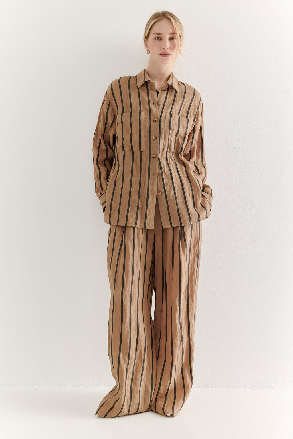 Person wearing a brown and beige striped outfit on a white background