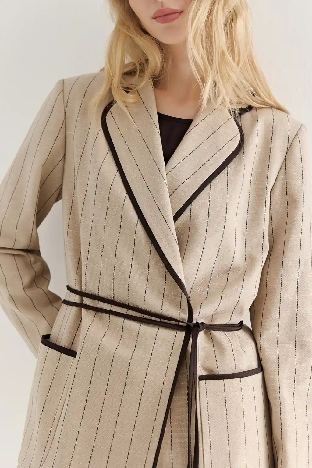 Beautiful Woman wearing AYRA STORE Sand Piped Safari Luxury Blazer in pinstriped lyocell-linen melange with dark contrasting piped trim