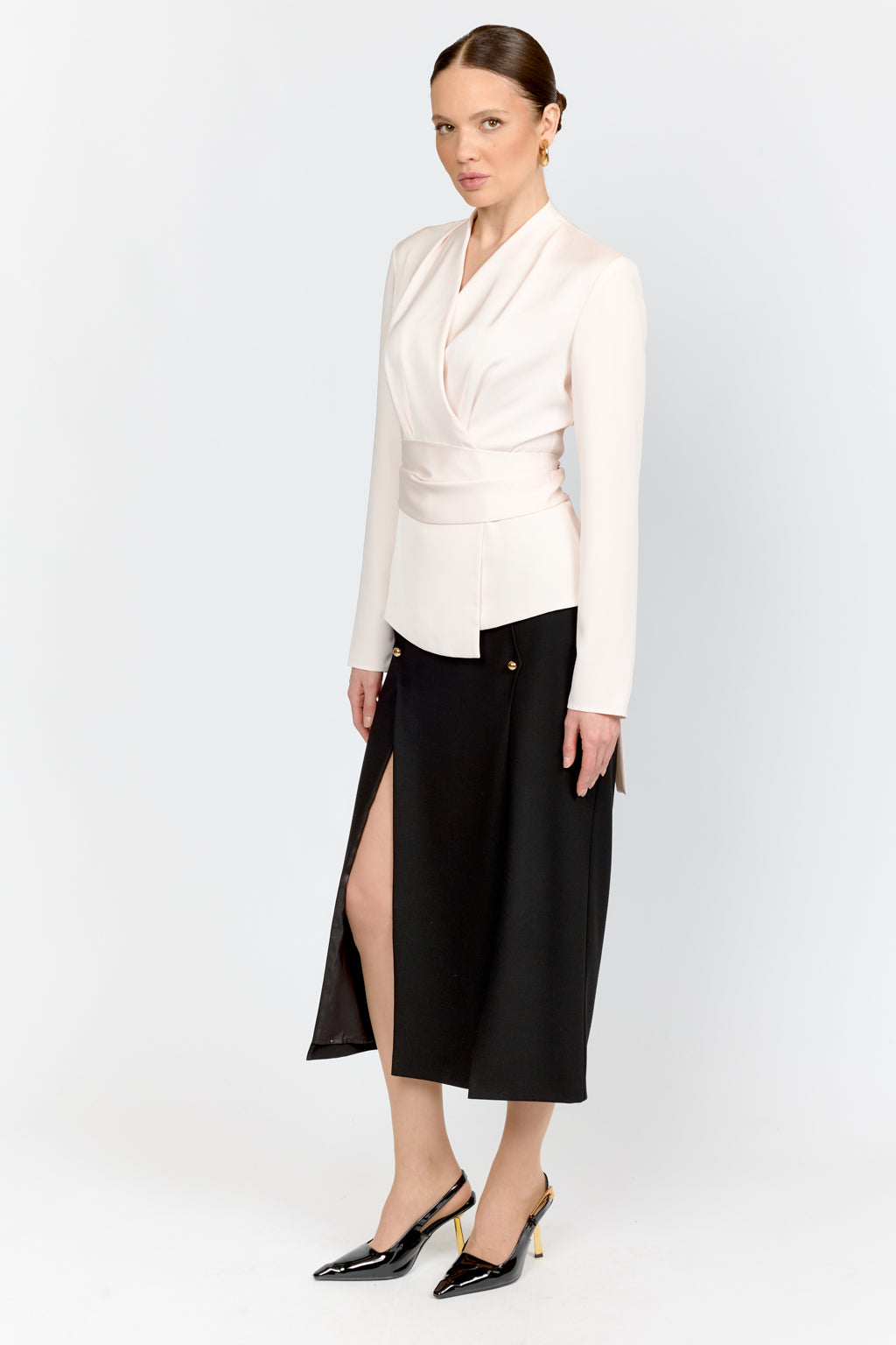Woman wearing a white blouse and black skirt on a white background