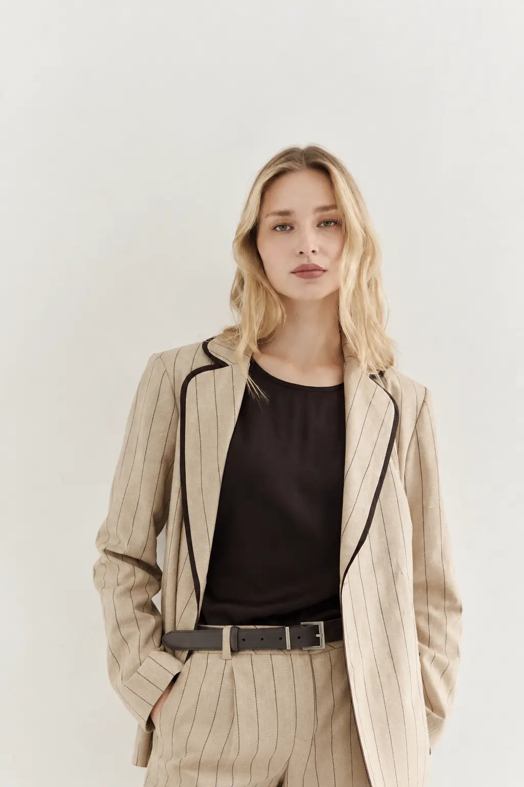 Beautiful Woman wearing AYRA STORE Sand Piped Safari Luxury Blazer in pinstriped lyocell-linen melange with dark contrasting piped trim