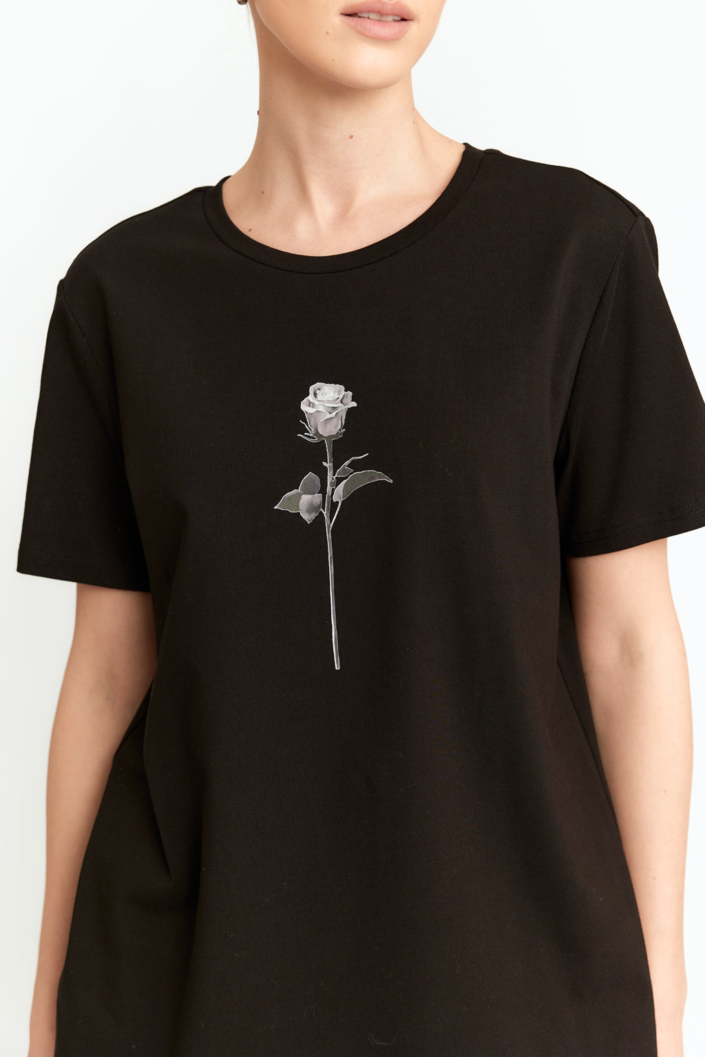 Black t-shirt with a white rose design on a plain background