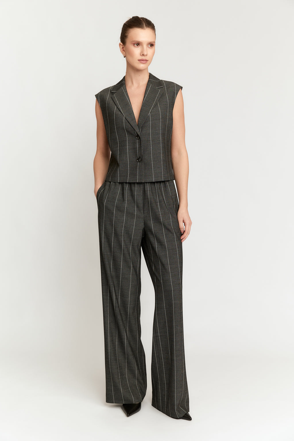 Woman wearing a gray pinstripe suit on a white background