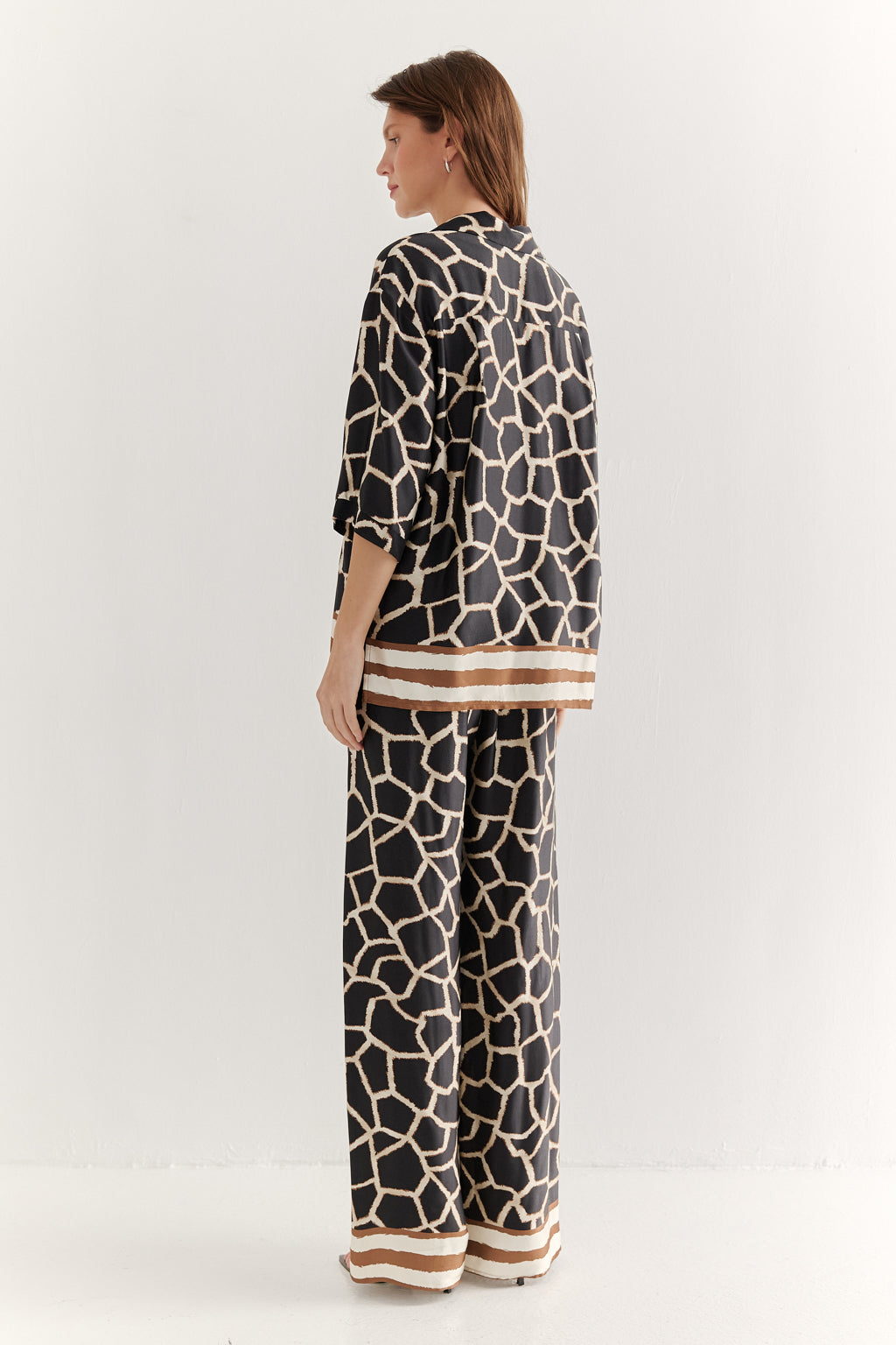 Woman wearing a black and white patterned outfit on a white background