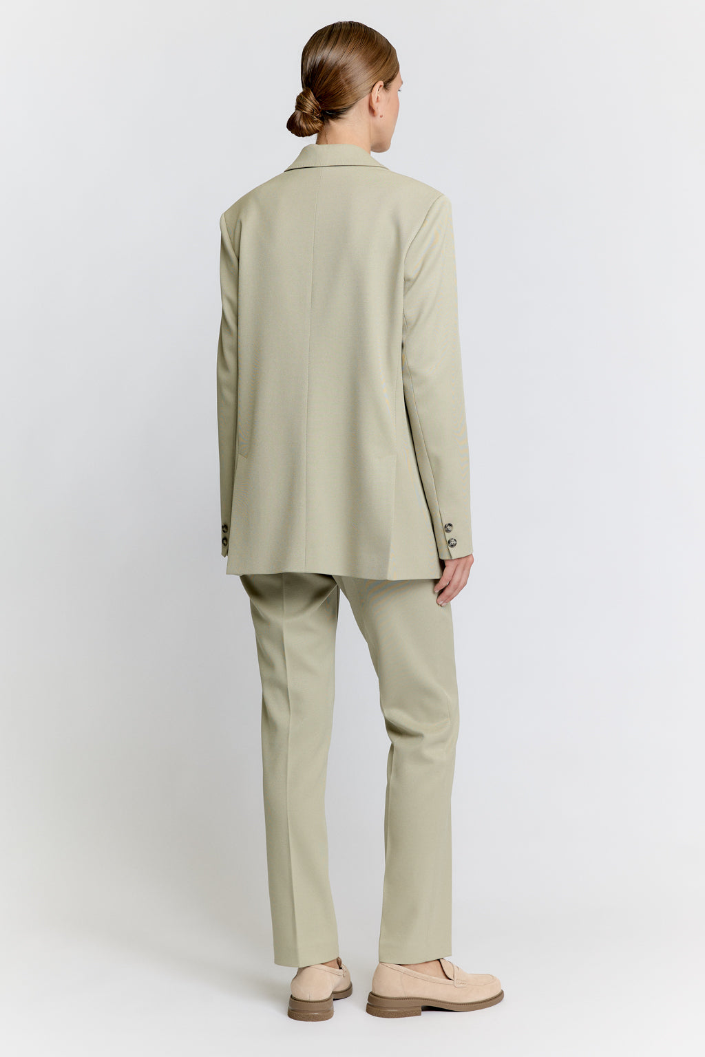 Person wearing a beige suit on a white background