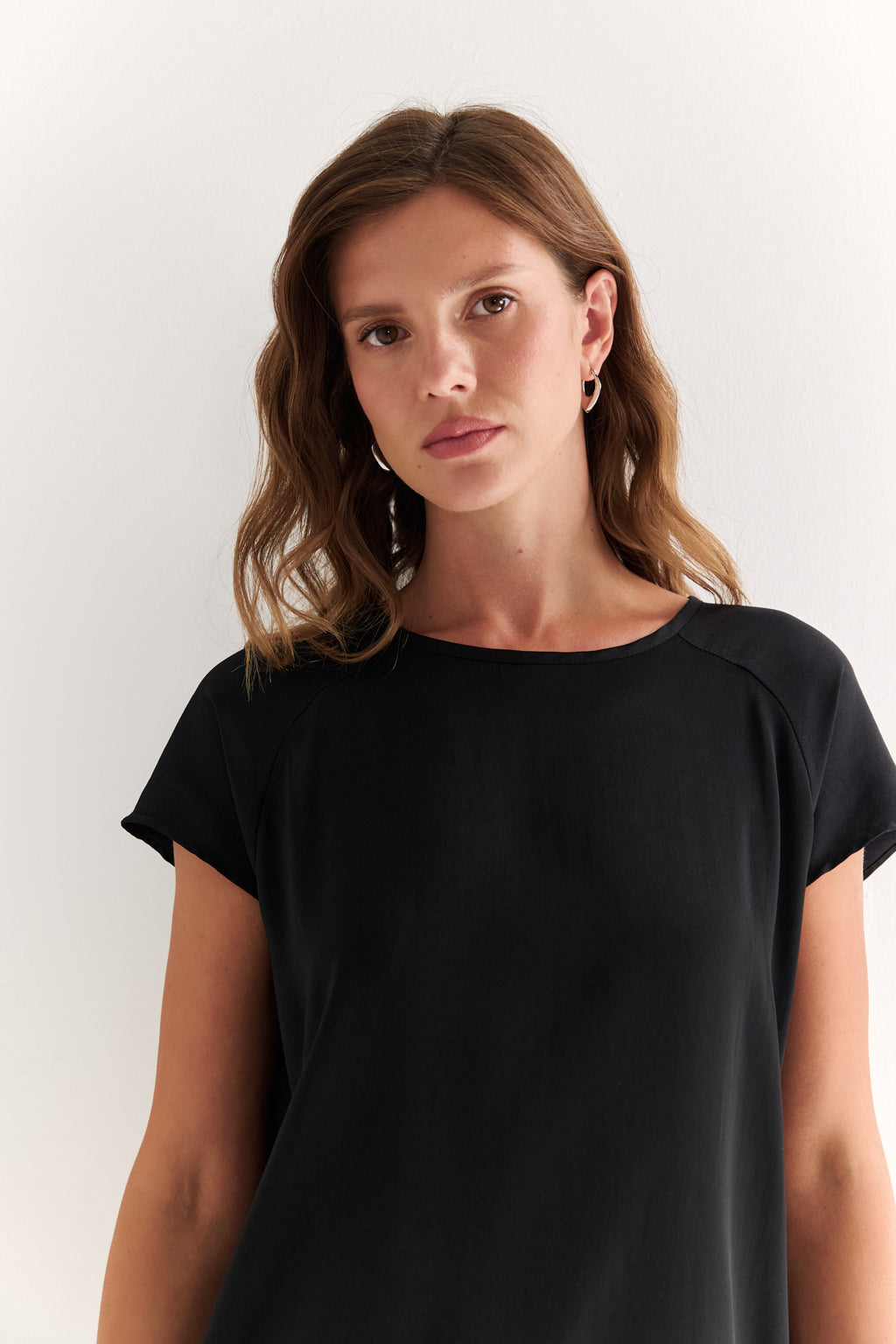 Woman wearing a black t-shirt against a white background