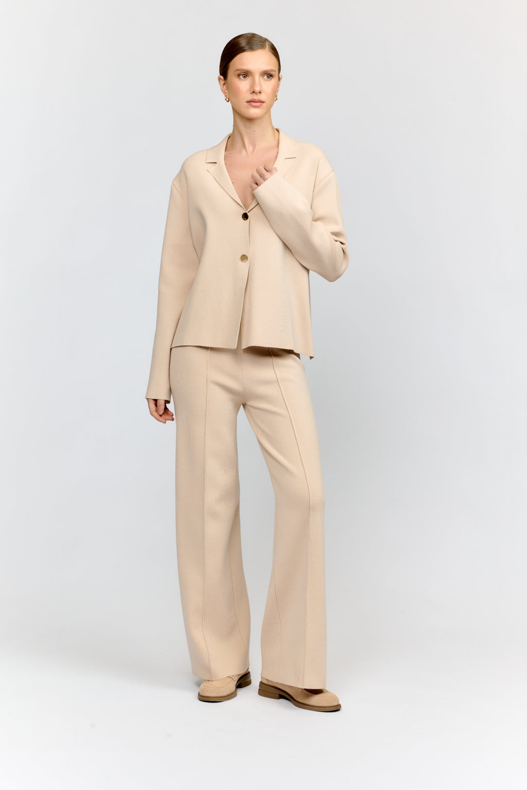Woman wearing a beige suit on a white background