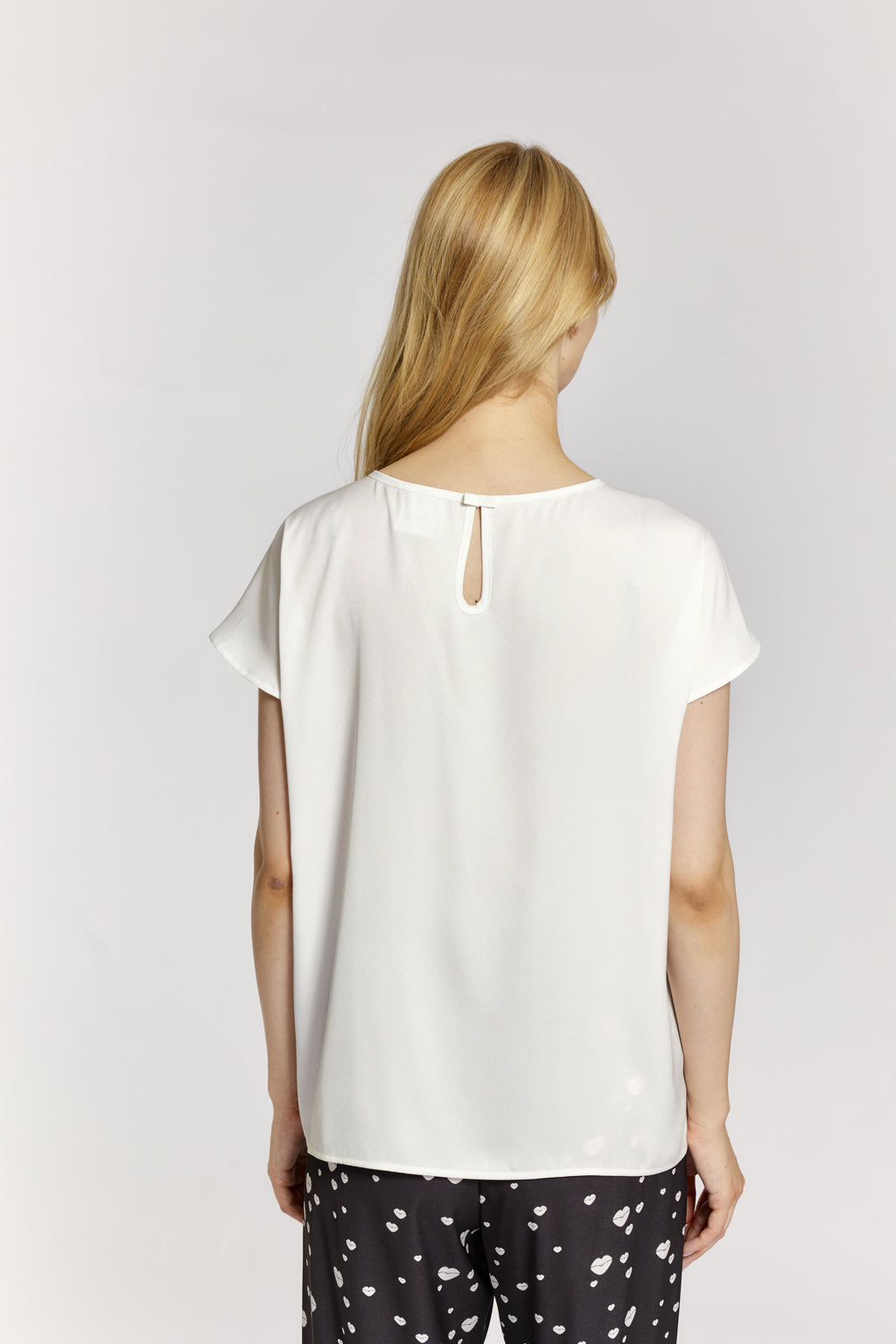 Woman wearing a white blouse with a plain background