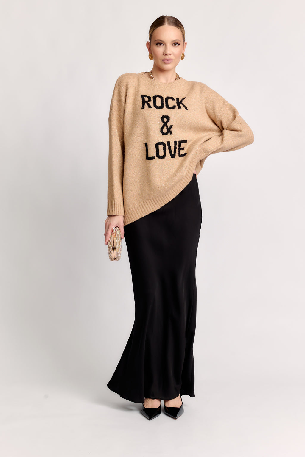 Woman wearing a beige sweater with 'Rock & Love' text and a black skirt on a white background