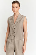 Woman wearing a beige pinstripe suit on a white background