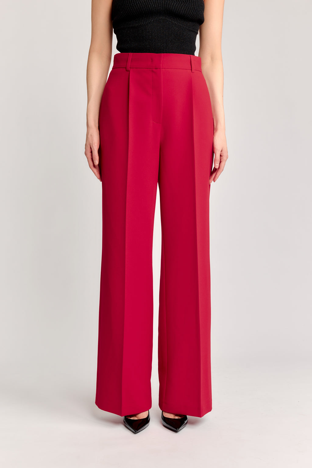 Red pants worn by a person on a light gray background