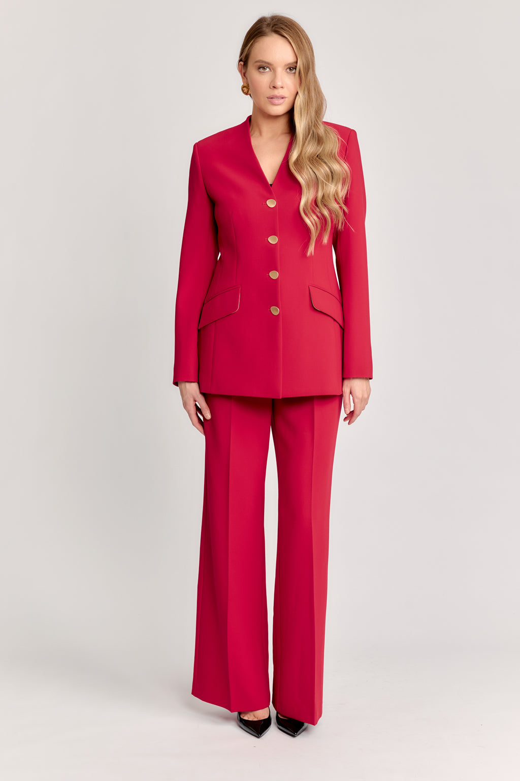 Woman wearing a red suit on a light gray background