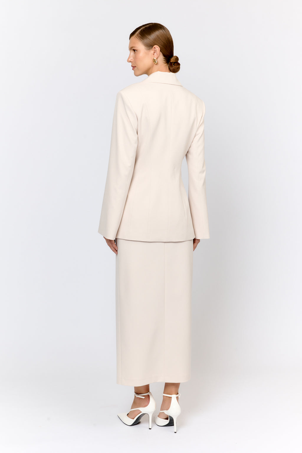 Woman wearing a beige suit on a white background
